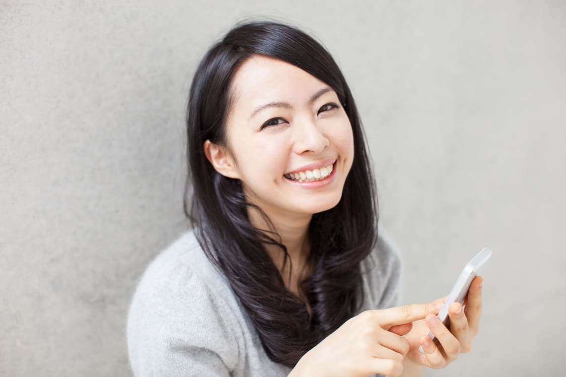 スマートフォンでオンライン相談を利用する女性